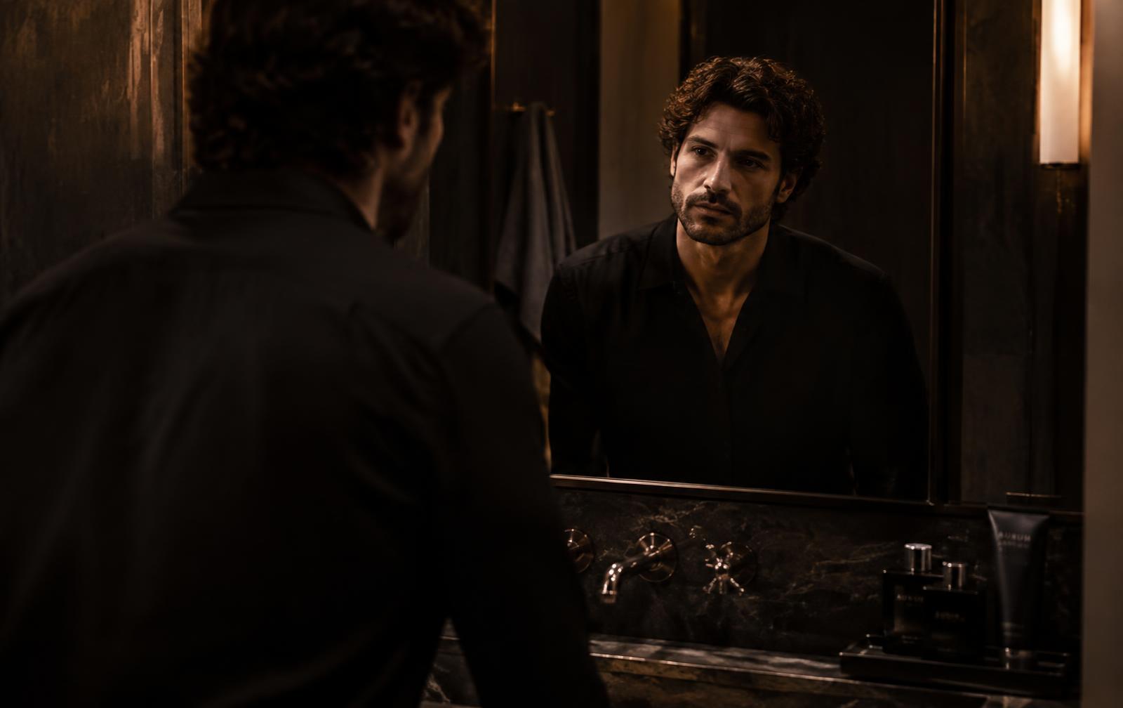 Man looking at his curls in the mirror